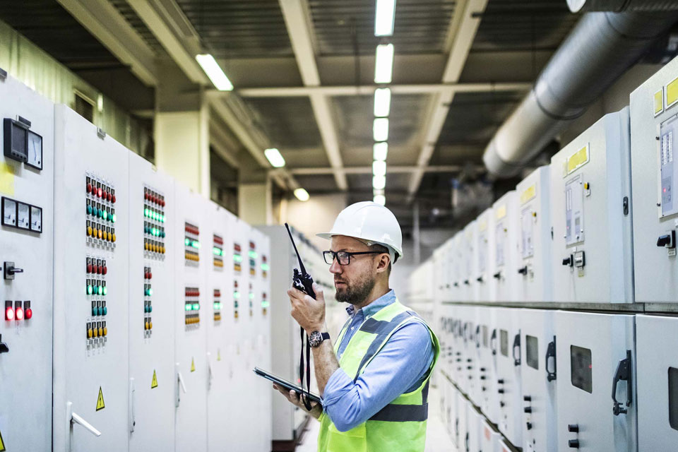 Man wearing a hard hat and neon vest conducting an energy audit for IonicBlue LLC