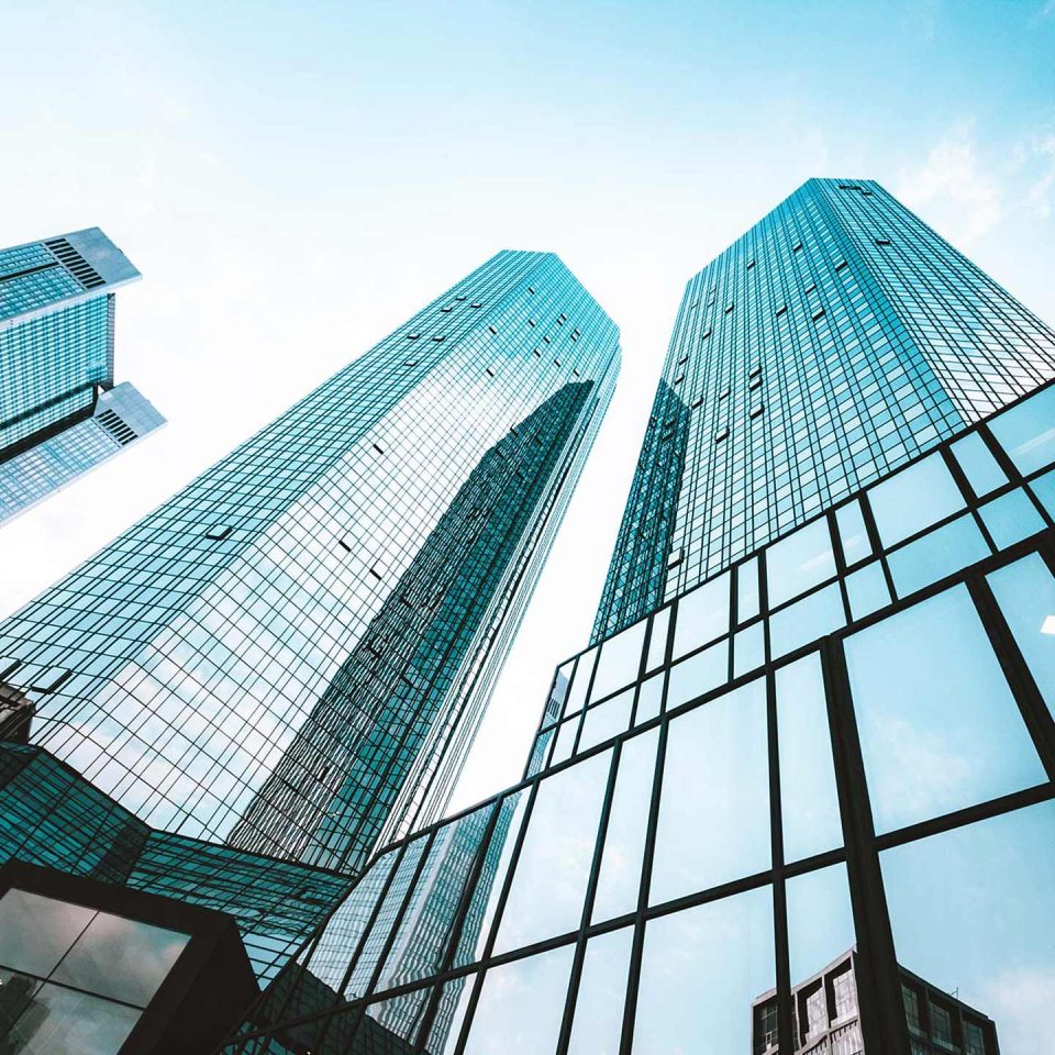 Skyscrapers pointing toward the sky reflecting the clouds above